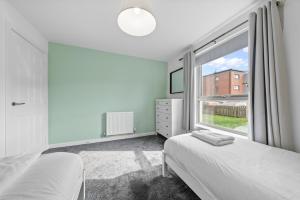 a bedroom with two beds and a large window at Castle View in Stirling