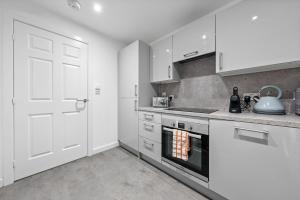 a kitchen with white cabinets and a stove top oven at Castle View in Stirling