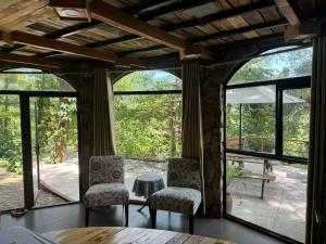two chairs and a table in a room with windows at DeBay Retreat - Little Đà Lạt Chill Villa in Sóc Sơn