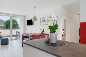 a kitchen and living room with a vase of flowers on a counter at Bike Apartments Curti - Abendrot in Laives