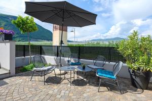 a patio with a table and chairs and an umbrella at Bike Apartments Curti - Abendrot in Laives