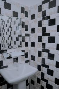 a bathroom with a sink and black and white tiles at Blue9 Hotel in Jaffna +4 photos