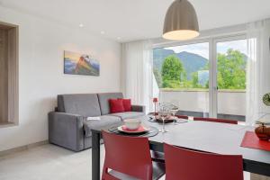 a dining room and living room with a table and chairs at Bike Apartments Curti - Abendrot in Laives