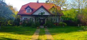 a small house with a red roof on a green yard at Apartament Urocze miejsce in Kazimierz Dolny