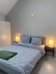 a bedroom with a bed and two lamps on tables at Robert 20 Brussels-charleroi-airport in Charleroi