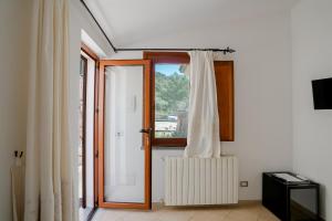 a room with a door and a window with a curtain at Giardini Malaspina in Bosa