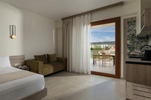 a hotel room with a bed and a sliding glass door at KLG Studios and Apartment in Nikiti