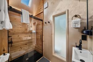 a bathroom with a shower and a toilet and a sink at Asheville River Cabins, WorldHotels Backdrop in Arden +277 photos