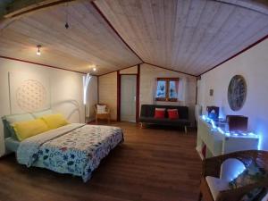 a bedroom with a bed and a couch in a room at Le Temple Ysambre in Malansac