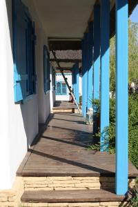 a wooden walkway outside of a building with blue windows at 5 Chirpici - Small Traditional Resort in Murighiol