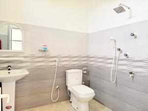 a bathroom with a toilet and a sink at Garden Beach Hotel in Arugam Bay
