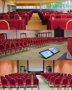 a conference room with red tables and chairs and a podium at Four Points by Sheraton Padova in Padova