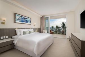 a white bedroom with a large bed and a balcony at Clarita's Beach Bar & Resort, WorldHotels Elite in Jacó +80 photos