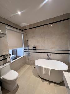a bathroom with a white tub and a toilet at Ngoc Dang Anh Hotel in Nhơn Trạch +17 photos