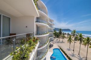 an apartment building with a view of the beach at Clarita's Beach Bar & Resort, WorldHotels Elite in Jacó