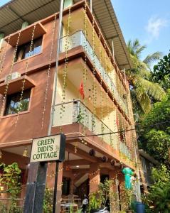 a building with a sign in front of it at Green Didis Cottage in Nagaon
