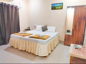 a bedroom with a bed with two towels on it at Green Didis Cottage in Nagaon