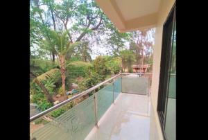 a balcony with a view of a garden and trees at Green Didis Cottage in Nagaon
