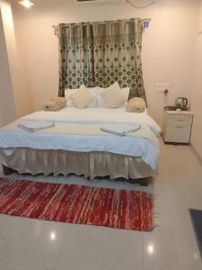 a bedroom with a large bed with a rug at Green Didis Cottage in Nagaon +8 photos