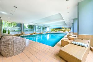 an indoor swimming pool with lounge chairs and a swimming pool at relexa hotel Bad Steben in Bad Steben