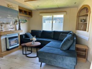 a living room with a blue couch and a fireplace at Beach Resort Kamperland - 1123 in Kamperland