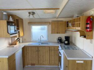 a kitchen with wooden cabinets and a sink and a window at Beach Resort Kamperland - 1123 in Kamperland