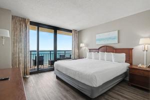 a hotel room with a bed and a balcony at The Patricia Grand in Myrtle Beach