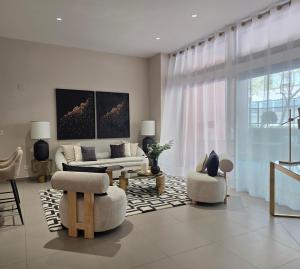 a living room with a white couch and chairs at MD Valterna Suites & Pool in Paterna