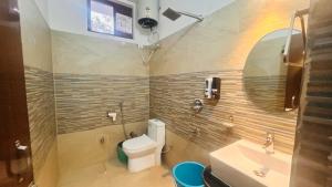 a bathroom with a toilet and a sink and a mirror at Hotel Red Sapphire Kushinagar in Kushinagar