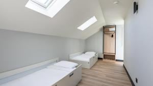 a white room with two beds and a skylight at Campanile NATURE - Vannes in Vannes