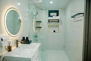 a white bathroom with a shower and a sink at Halo Motel Đồ Sơn in Ðố Sơn +29 photos