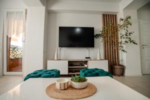 a living room with a table with two chairs and a tv at Ohrid Pearl Apartment in Ohrid