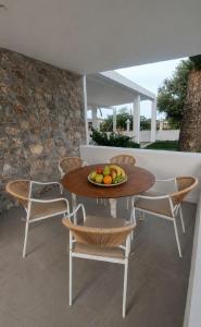a table and chairs with a bowl of fruit on it at Aelia House Kefalos - Cozy & Quiet in Kos