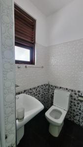 a bathroom with a toilet and a bath tub at Polhena Neptune Resort in Matara