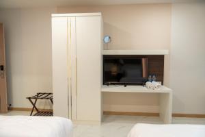 a white cabinet in a bedroom with a television at Jaroon House in Samutprakarn +10 photos