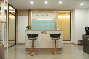 a lobby with a bar with two stools at Jaroon House in Samutprakarn