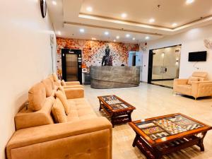 a living room with two couches and a tv at Hotel Red Sapphire Kushinagar in Kushinagar