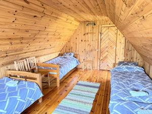 a room with two beds in a log cabin at Diby Kämping saunamaja numbritoad in Diibi