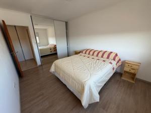 a small bedroom with a bed and a mirror at LuxApart in Caleta Olivia