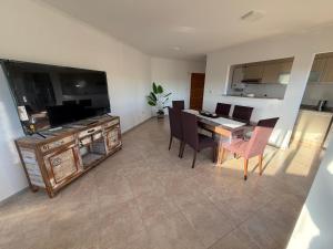 a living room with a dining room table and chairs at LuxApart in Caleta Olivia