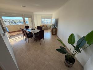 a dining room and living room with a table and a plant at LuxApart in Caleta Olivia