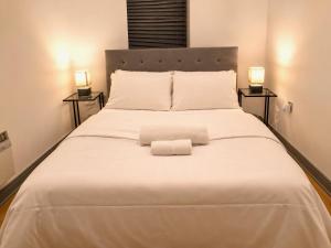 a large white bed with two lamps on both sides at York City Centre 1-bed Apartment Near Q-Park Parking - Best Location in York