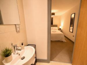 a bathroom with a sink and a room with a bed at York City Centre 1-bed Apartment Near Q-Park Parking - Best Location in York