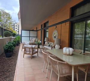 an outdoor patio with tables and chairs and windows at MD Valterna Suites & Pool in Paterna