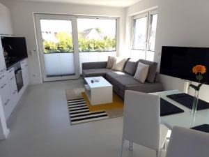 a living room with a couch and a table at Haus am Wittenwiewerbarg in Dahme +4 photos