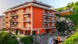 an orange building on the side of a mountain at Hotel Tirreno in Lavagna
