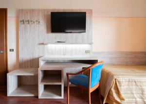 a room with a desk with a tv and a chair at Hotel Tirreno in Lavagna