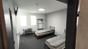 a room with two beds and a desk in it at Pavelkova House in Olomouc