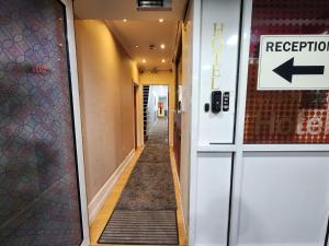 an empty hallway of a building with an exit sign at Lyon House Hotel in Barking