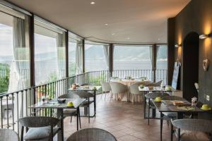 a restaurant with tables and chairs and large windows at Relais Villa Porta in Luino